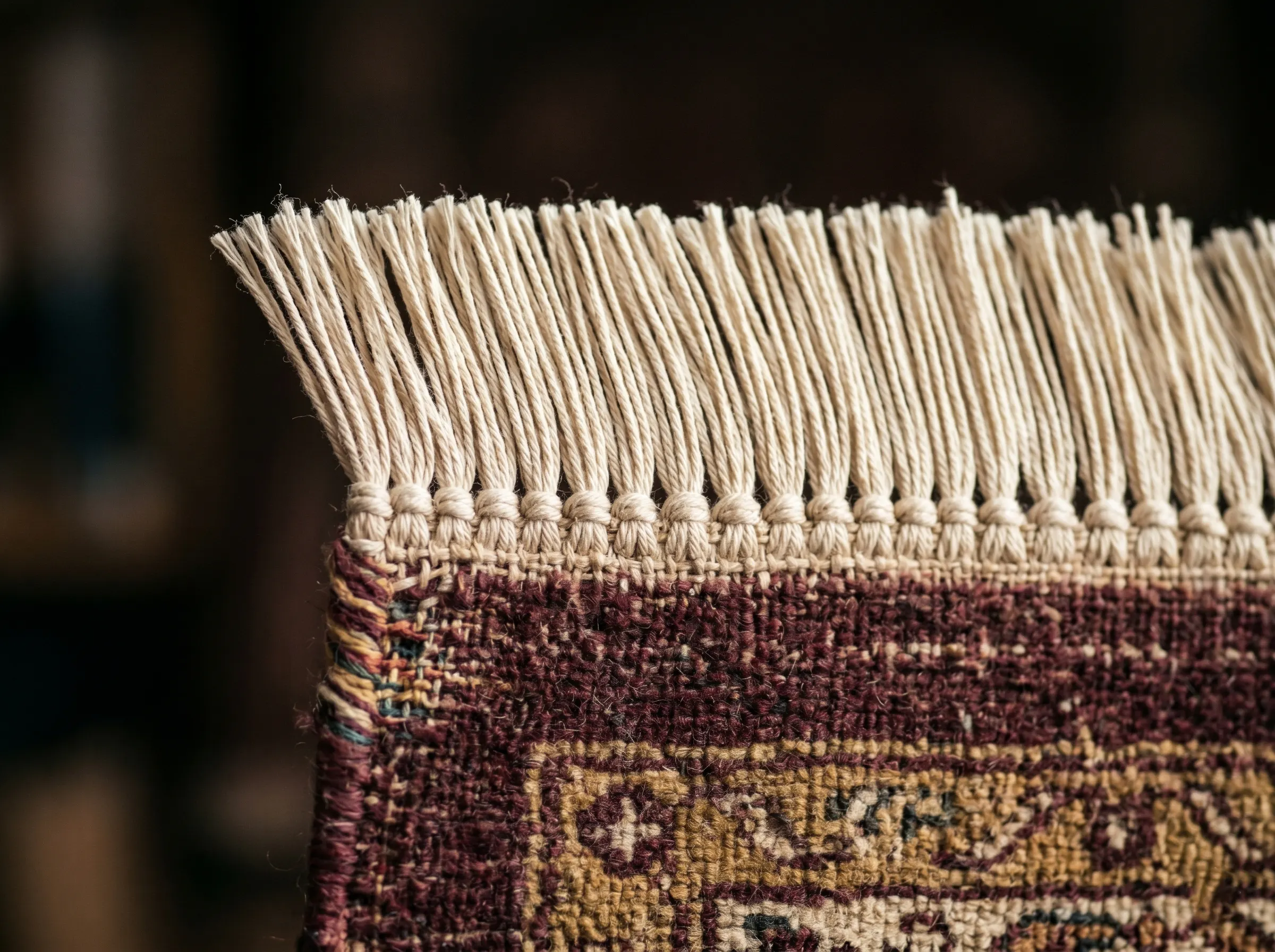 Franges reconstituées à la main par un artisan tapissier après restauration d'un tapis persan ancien